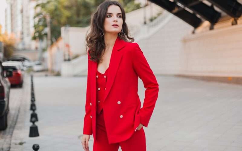business woman in red Blazer walking in city street