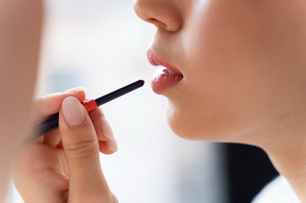 close up woman applying lip liner