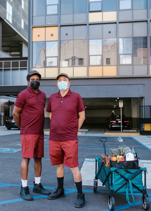 two men standing outside the shopping center wearing red short and red t- shirt